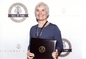 Martha Violett holds an award after her induction to the Steinway & Sons Hall of Fame